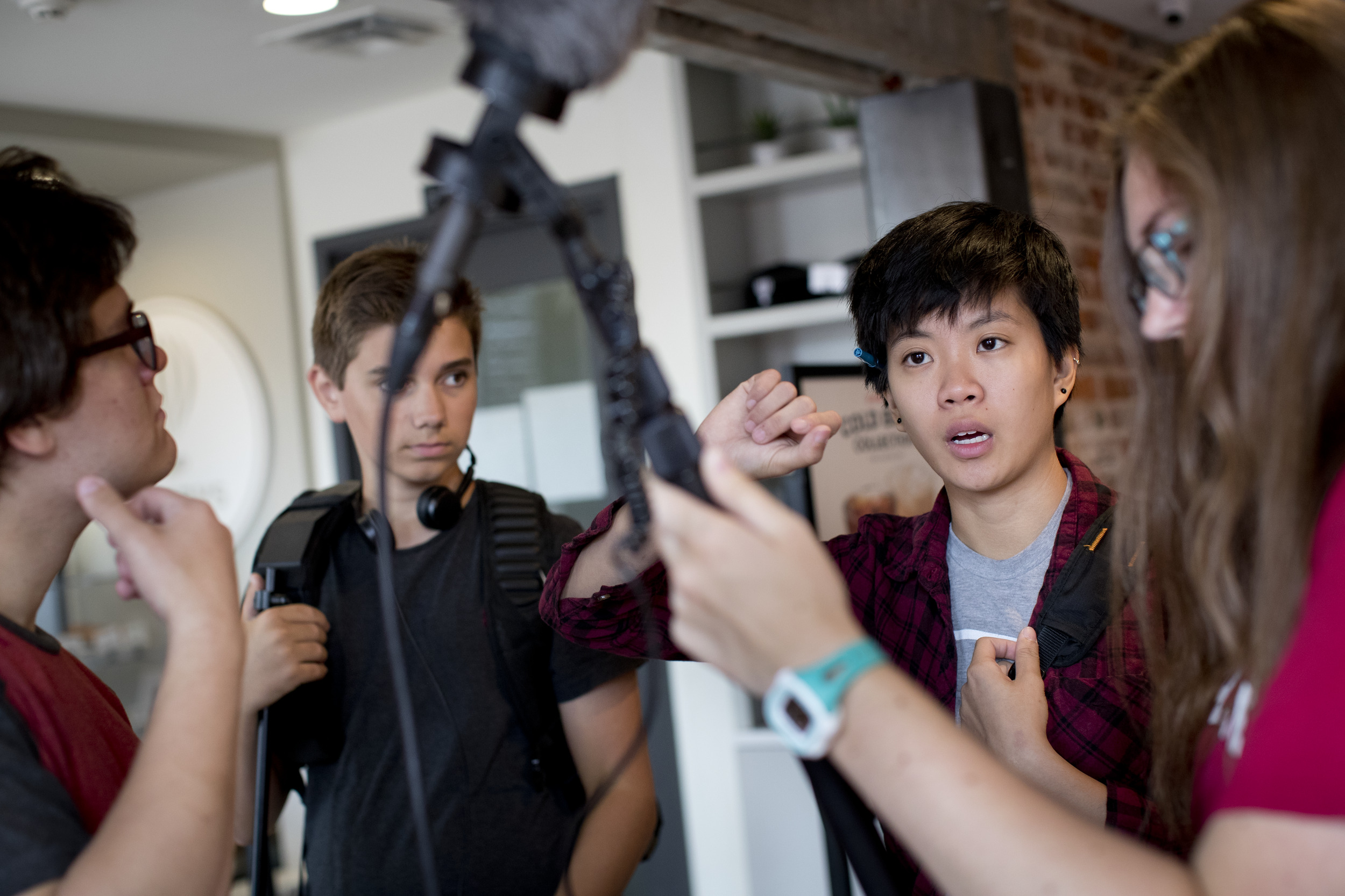 High school students work together on setting up a microphone.