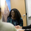 A woman is shown laughing while sitting with two others.