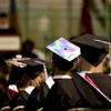 An image of Students facing the stage at commencement dressed in their caps and gowns.